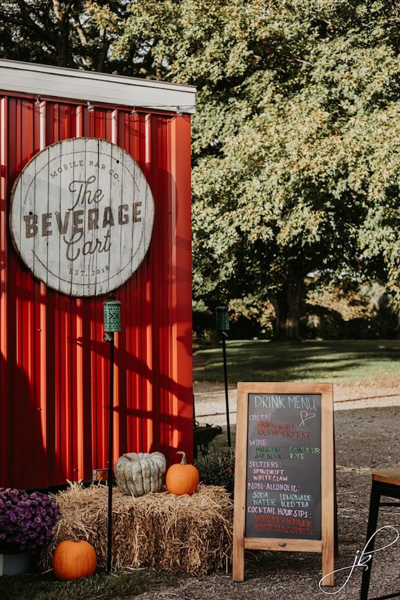 Beverage cart at outdoor wedding ceremony during fall season wedding.