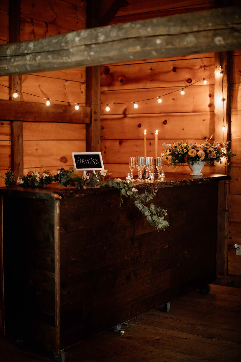 Rustic event space with bar inside barn for weddings.