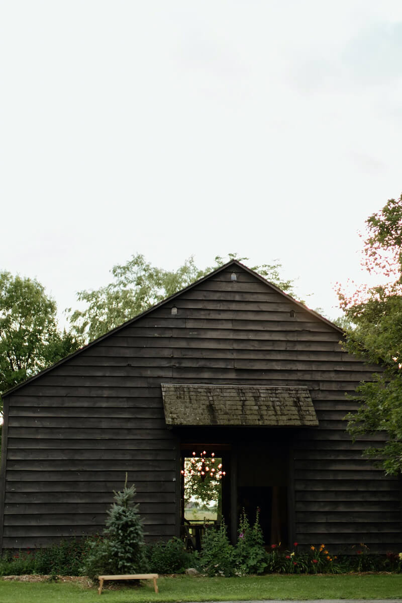 Rustic barn surrounded by plants and trees at Providence Barn.